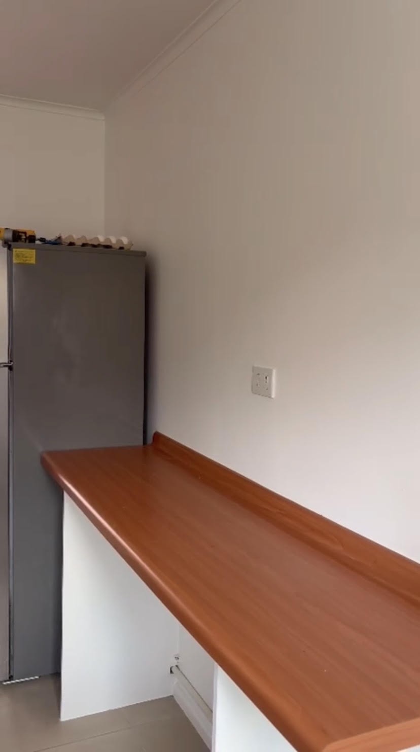 Antes: cocina sin muebles, con refrigerador y un mesón de melamina naranja