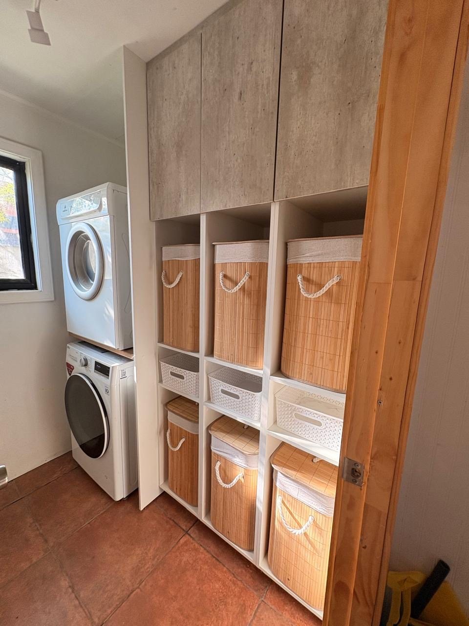 Después: lavandería ordenada con muebles altos, repisas y canastos